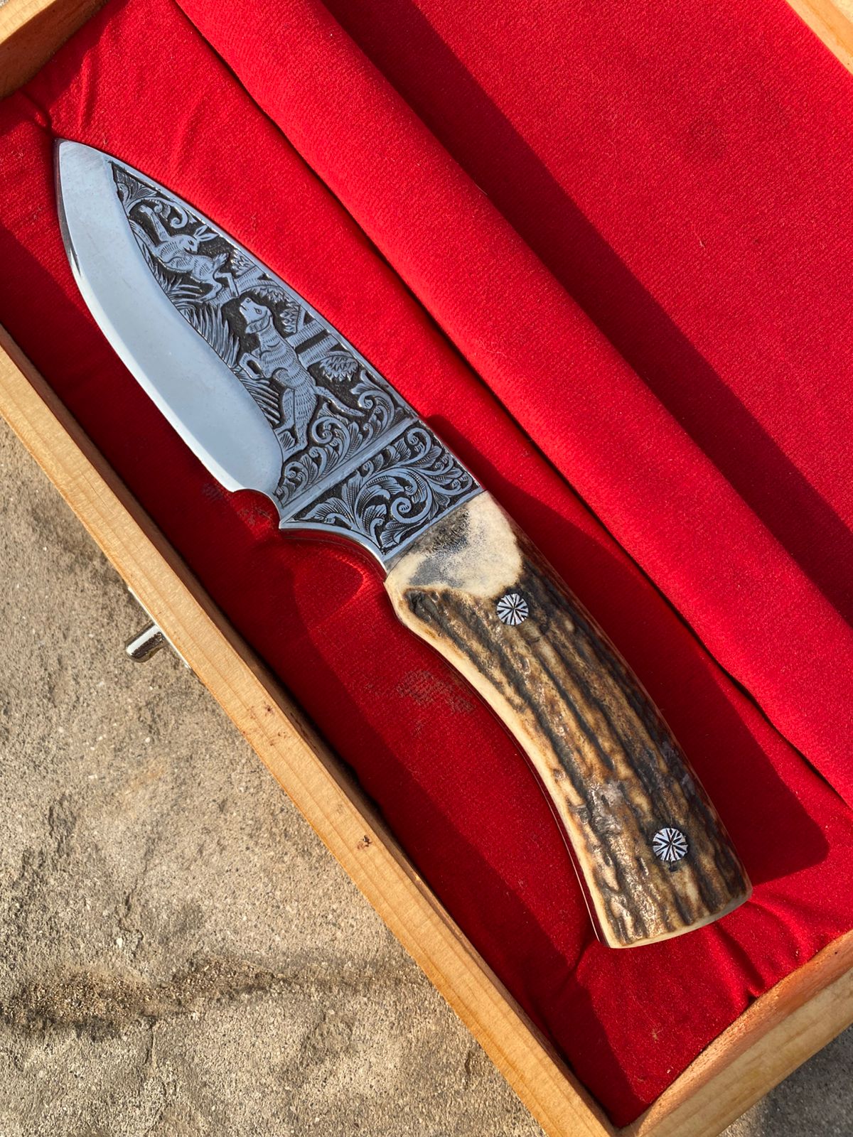 Custom handmade hunting bowie knife with stag horn handle and engraved artistry on blade
