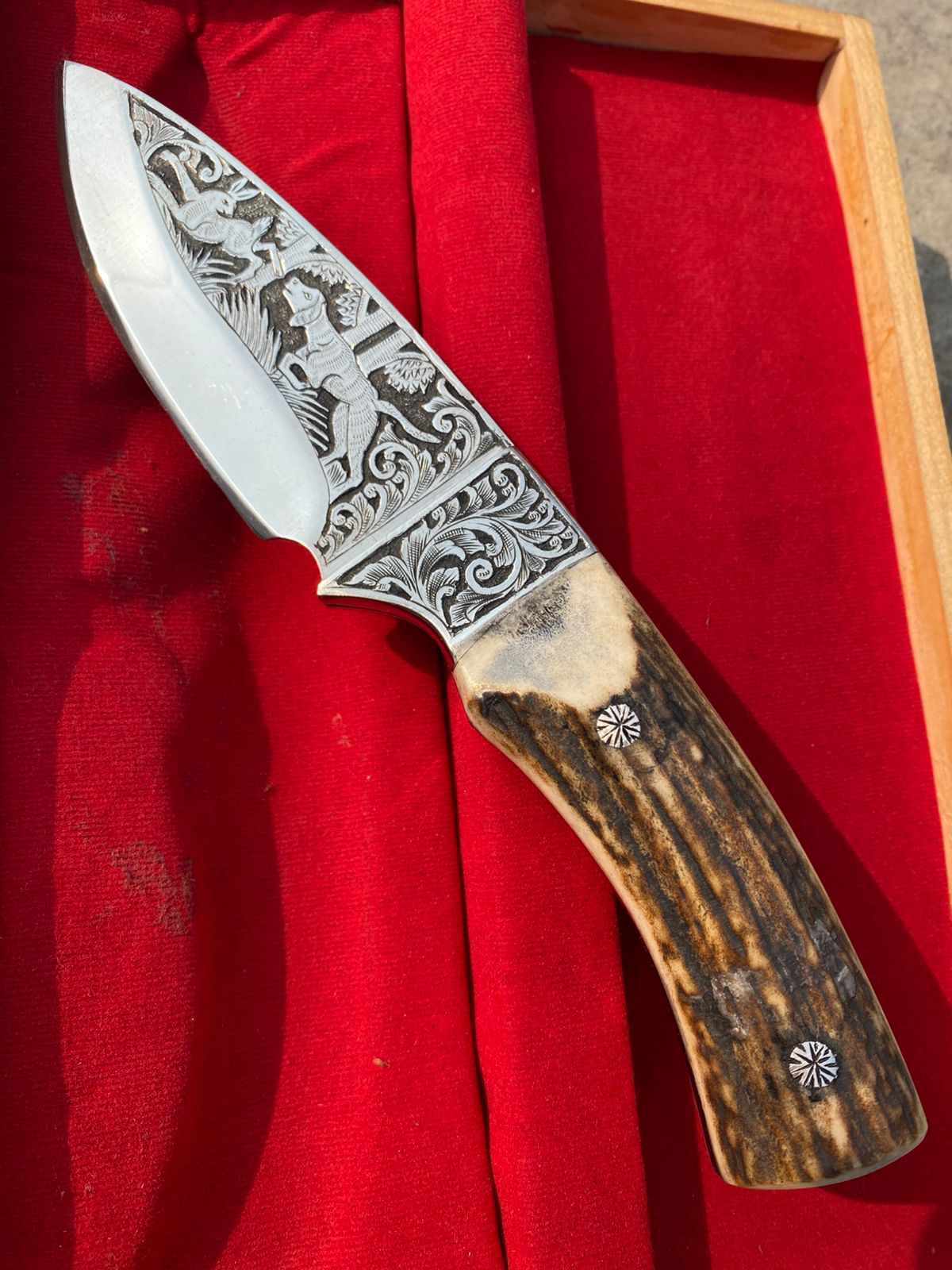 Custom handmade hunting bowie knife with stag horn handle and engraved artistry on blade