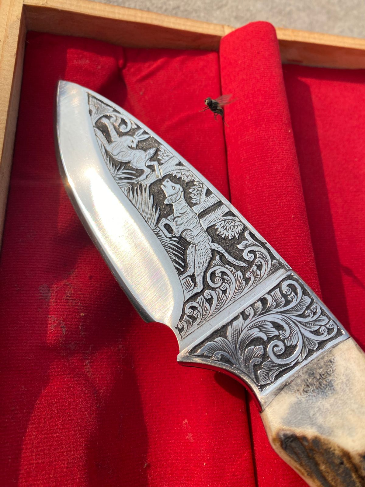 Custom handmade hunting bowie knife with stag horn handle and engraved artistry on blade