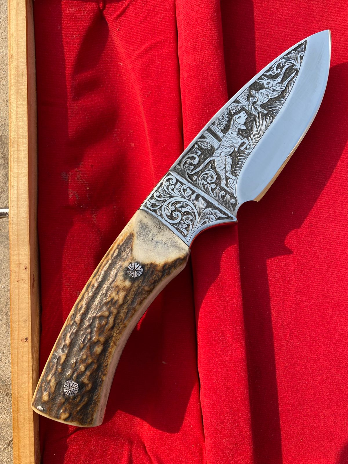 Custom handmade hunting bowie knife with stag horn handle and engraved artistry on blade