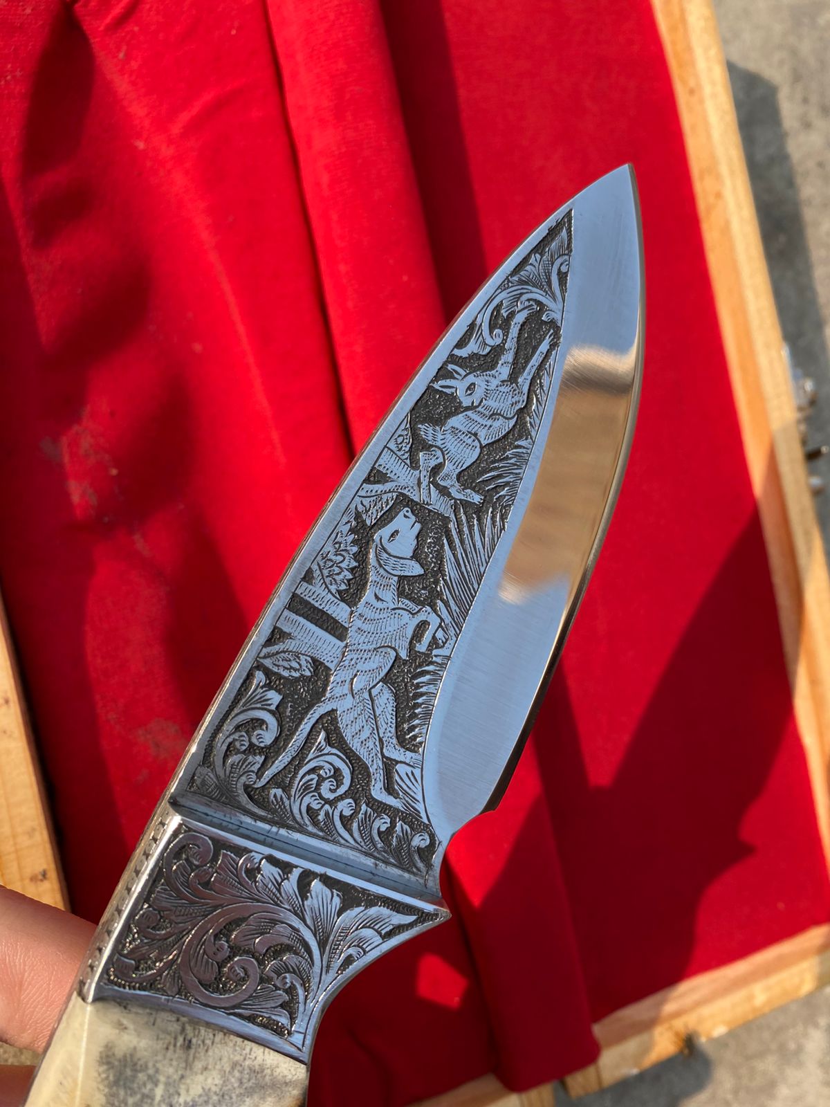 Custom handmade hunting bowie knife with stag horn handle and engraved artistry on blade