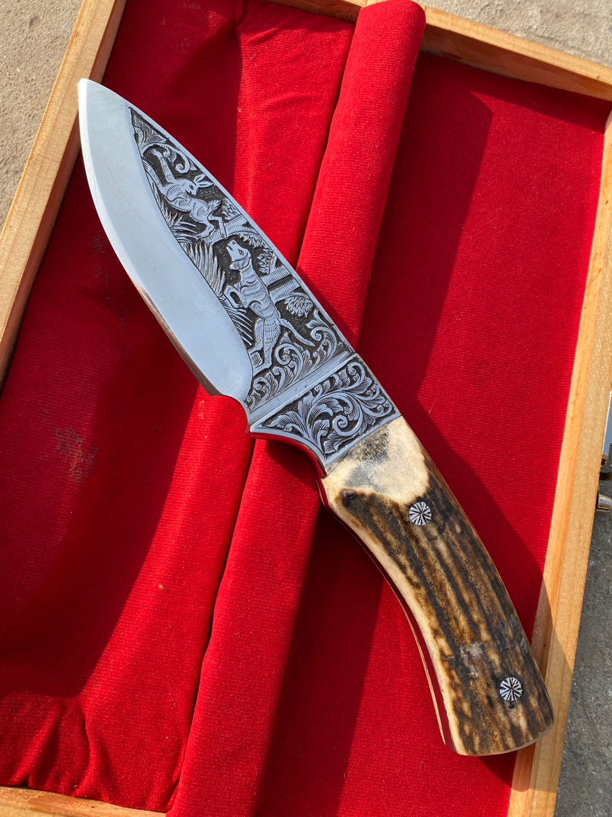 Custom handmade hunting bowie knife with stag horn handle and engraved artistry on blade